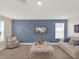 A beautifully decorated living room showcases modern furniture, a blue accent wall, and bright natural light at 565 Big Pine Ave, Minneola, FL 34715