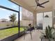 Screened patio with furniture, ceiling fan, roll-down sunshade, and view of the fenced backyard and blue sky at 565 Big Pine Ave, Minneola, FL 34715