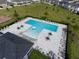 A community pool with lounge chairs, umbrellas, and surrounding landscaped area at 565 Big Pine Ave, Minneola, FL 34715