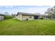 Backyard featuring lush green lawn with home exterior in background at 620 Wexford Ct, Winter Haven, FL 33884