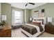 This spacious bedroom is nicely decorated with muted greens, modern fixtures, and a comfortable, upholstered bed at 6257 Dew Drop Loop, St Cloud, FL 34771