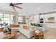 Open-concept living room and kitchen with white cabinetry, center island, and stainless steel appliances at 6257 Dew Drop Loop, St Cloud, FL 34771