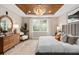 Inviting main bedroom featuring a wood tray ceiling, a large window, stylish decor, and comfortable furnishings at 6257 Dew Drop Loop, St Cloud, FL 34771