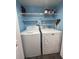 Laundry room with washer, dryer, overhead shelving and blue walls at 631 Grenadine Ct # 631, Winter Park, FL 32792