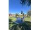 Scenic view of a pond in the community with a fountain, green grass, and buildings at 631 Grenadine Ct # 631, Winter Park, FL 32792