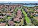 Community aerial showing residential houses with terracotta roofs near a lake at 6992 Brescia Way, Orlando, FL 32819