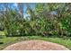 Landscaped backyard featuring a brick patio and lush tropical foliage at 6992 Brescia Way, Orlando, FL 32819