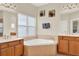 Serene bathroom with a corner tub, dual vanities, and ample natural light for a spa-like experience at 6992 Brescia Way, Orlando, FL 32819