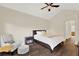 Relaxing bedroom showcasing a vaulted ceiling, dark wood floors, and comfortable seating area at 6992 Brescia Way, Orlando, FL 32819