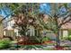 Charming two-story home with a tile roof, mature trees, and manicured lawn at 6992 Brescia Way, Orlando, FL 32819