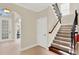 Inviting foyer featuring a staircase with decorative iron spindles and tile flooring at 6992 Brescia Way, Orlando, FL 32819