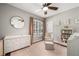 Bright Bedroom with soft pink accents, a changing table, and a round mirror at 707 Brandy Oaks Loop, Winter Garden, FL 34787