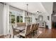 Elegant dining area with large windows, hardwood floors, and stylish furnishings at 707 Brandy Oaks Loop, Winter Garden, FL 34787