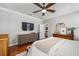 Spacious main bedroom with wood floors, a ceiling fan, dresser, and flat screen television at 707 Brandy Oaks Loop, Winter Garden, FL 34787