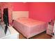 Vibrant pink bedroom featuring a bed, dresser, and playful decor at 7756 Beridale Ct, Orlando, FL 32818