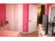 Bright pink bedroom includes closet, dresser, and view to another room at 7756 Beridale Ct, Orlando, FL 32818