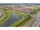 An aerial shot reveals a community near a lake and highway, with charming terra-cotta roofs on the townhomes at 8742 European Fan Palm Aly, Winter Garden, FL 34787