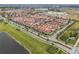 Expansive aerial view of a community featuring townhomes, a lake, and picturesque landscaping with palm trees at 8742 European Fan Palm Aly, Winter Garden, FL 34787