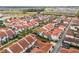 Wide aerial view of a townhome community featuring vibrant terra cotta roofs and lush landscaping at 8742 European Fan Palm Aly, Winter Garden, FL 34787