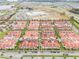 A vibrant aerial perspective of a townhome community highlighted by lush landscaping and terra cotta roofs at 8742 European Fan Palm Aly, Winter Garden, FL 34787