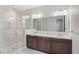 Modern bathroom with glass walk-in shower, double sinks, and dark wooden vanity at 8742 European Fan Palm Aly, Winter Garden, FL 34787