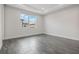 Minimalist bedroom with grey plank flooring and a window bringing in natural light at 8742 European Fan Palm Aly, Winter Garden, FL 34787