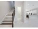 Bright entryway featuring tile floors, staircase, and glimpse into the modern kitchen at 8742 European Fan Palm Aly, Winter Garden, FL 34787