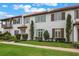 Stylish townhome exhibiting colorful shutters, verdant lawn, and landscaped entryway at 8742 European Fan Palm Aly, Winter Garden, FL 34787