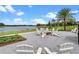 Outdoor fire pit and lounge area surrounded by seating, with a lake in the background at 8742 European Fan Palm Aly, Winter Garden, FL 34787