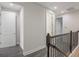 Upstairs hallway with plank floors and dark wood railings at 8742 European Fan Palm Aly, Winter Garden, FL 34787