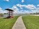 Community kayaks sit along a lush green walking path with picturesque lake views and a blue cloudy sky at 8742 European Fan Palm Aly, Winter Garden, FL 34787