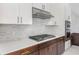 Close up of a kitchen featuring gas range, tile backsplash, and modern appliances at 8742 European Fan Palm Aly, Winter Garden, FL 34787