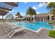 Large community pool with lounge chairs, clubhouse, water features, and lush tropical landscaping at 8742 European Fan Palm Aly, Winter Garden, FL 34787