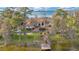 Aerial shot of a lakefront home featuring a dock, mature trees, and a manicured lawn on a sunny day at 9243 Point Cypress Dr, Orlando, FL 32836