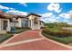 Attractive residence boasting a red brick driveway, white pillars, and professionally designed gardens at 9243 Point Cypress Dr, Orlando, FL 32836