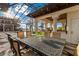 Outdoor dining area features an ornate table and seating with the pool and lake in the background at 9243 Point Cypress Dr, Orlando, FL 32836