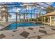 Indoor pool area with stone tile, an attached spa, lake views, and a retractable glass roof at 9243 Point Cypress Dr, Orlando, FL 32836