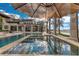 A covered outdoor living space beside a sparkling pool and spa, all encased in a screened enclosure at 9243 Point Cypress Dr, Orlando, FL 32836