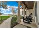 Inviting porch area with rocking chairs, stone pillars, and views of the lush landscaping and lake beyond at 9243 Point Cypress Dr, Orlando, FL 32836