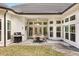 A covered patio with a table and chairs and a grill in the backyard at 9308 Thurloe Pl, Orlando, FL 32827