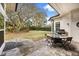 Inviting backyard patio area with pavers, grill, dining table and spacious lawn area at 9308 Thurloe Pl, Orlando, FL 32827