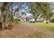 Backyard showing the home's exterior, landscaping, and mature trees at 9308 Thurloe Pl, Orlando, FL 32827