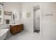 Luxury bathroom featuring a wood vanity, soaking tub, and marble tiled walk-in shower with glass door at 9308 Thurloe Pl, Orlando, FL 32827