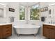 Luxury bathroom featuring double vanities, soaking tub, and windows with lots of natural light at 9308 Thurloe Pl, Orlando, FL 32827