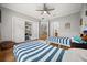 Bright bedroom featuring two twin beds with striped bedding, built-in shelving, and hardwood floors at 9308 Thurloe Pl, Orlando, FL 32827