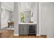 Hallway wet bar with grey cabinets, wine cooler and white countertop conveniently located near dining room at 9308 Thurloe Pl, Orlando, FL 32827