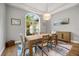 Light-filled dining room with a wooden table, neutral chairs, and large arched window at 9308 Thurloe Pl, Orlando, FL 32827