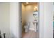 A powder room featuring a pedestal sink, toilet, and a round mirror over the sink at 9308 Thurloe Pl, Orlando, FL 32827