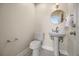 A powder room featuring a pedestal sink, toilet, mirror, and light fixture at 9308 Thurloe Pl, Orlando, FL 32827