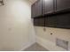 Practical laundry room with upper cabinets and washer and dryer hookups at 944 Brooklet Dr, Davenport, FL 33837